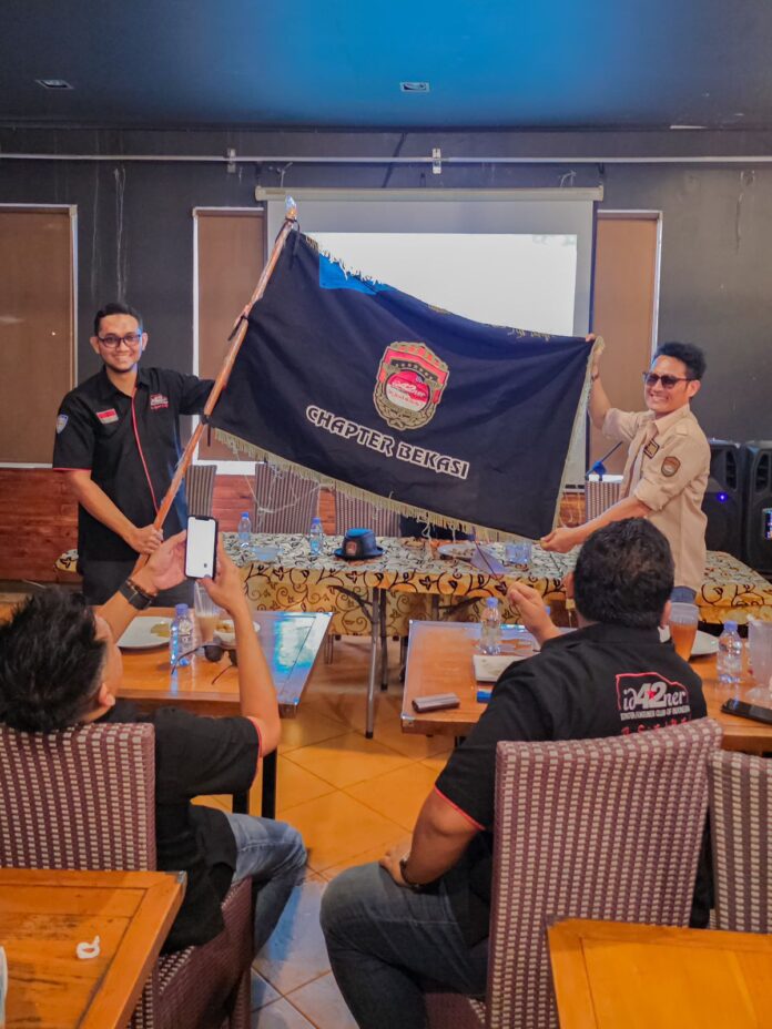 Rizki menerima bendera pengukuhan sebagai ketua ID42NER Chapter Bekasi