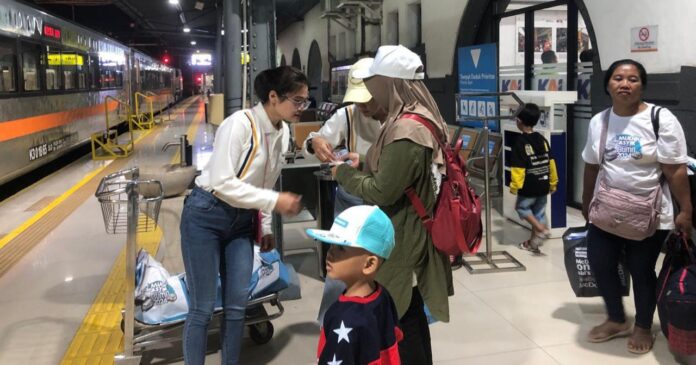 Seorang petugas melayani penumpang kereta. (Istimewa)